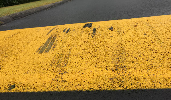 The second speed bump leading to the back student parking lot shows scrapes where the undercarriage of students' cars hit the surface,