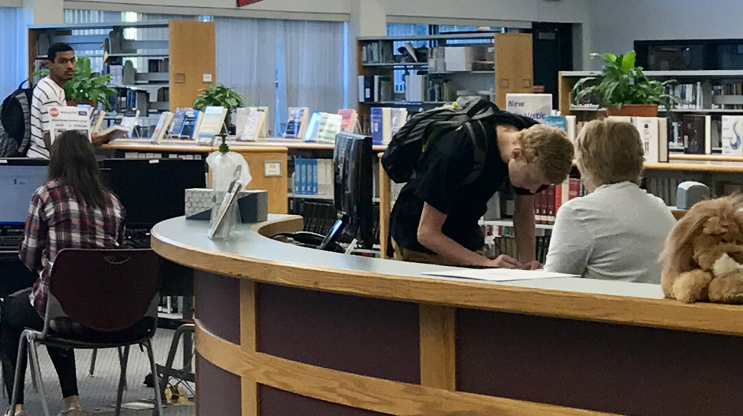 Senior Kyle Fortune signs in for a library pass before school.