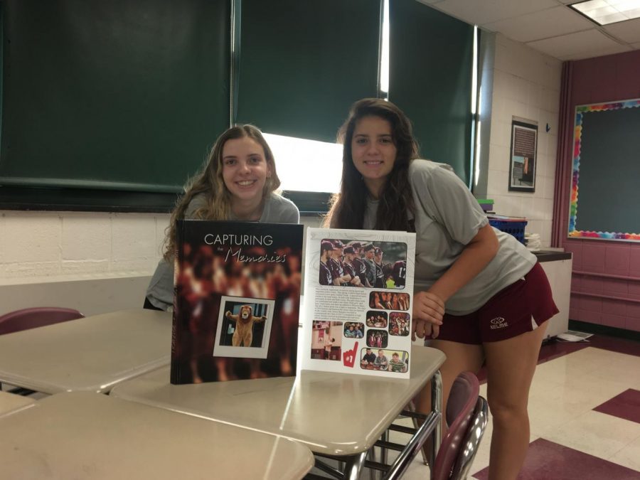 Seniors Kellie Salmond and Destiny Lavertue pose in front of last years yearbook 