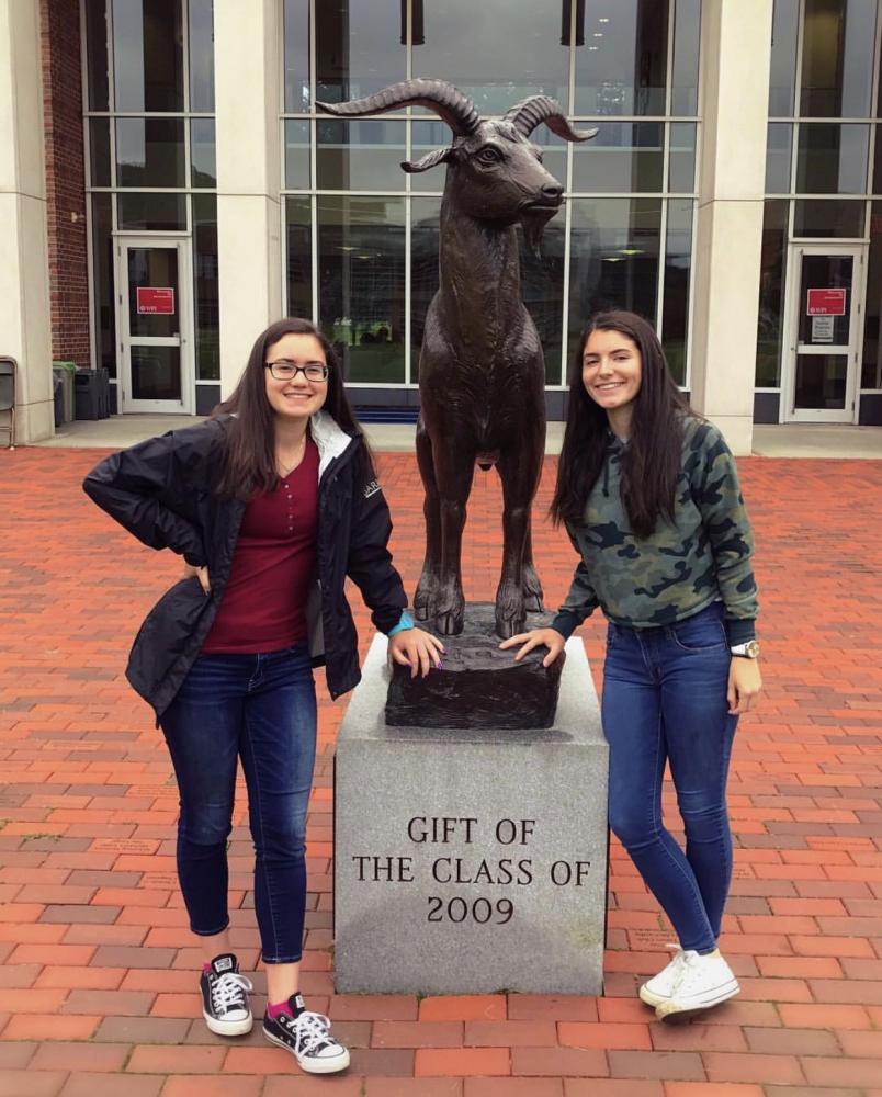 Seniors Katie Pereira and Jessica Pinto pose with the WPI goat statue after a campus tour. 