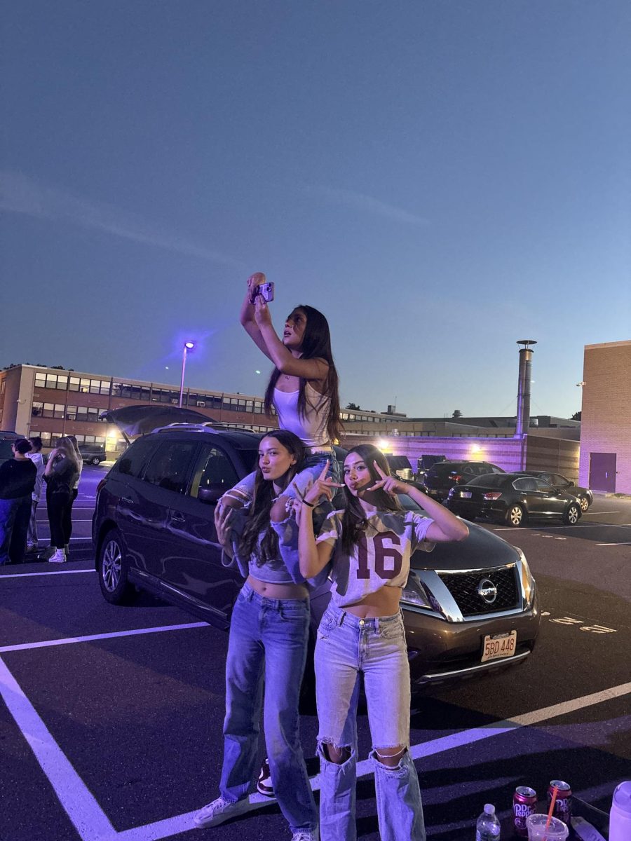 Senior Giani Perez and Ariana Malave, uses her cheer knowledge to get a good angle for the yearbook, and senior Maddy Marques poses next to them
